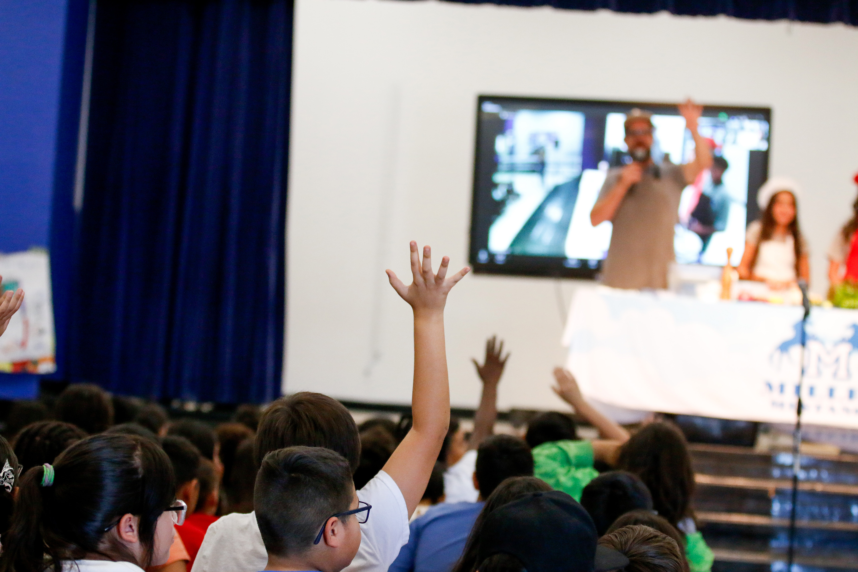 A student in the audience raises his hand during the chef demo