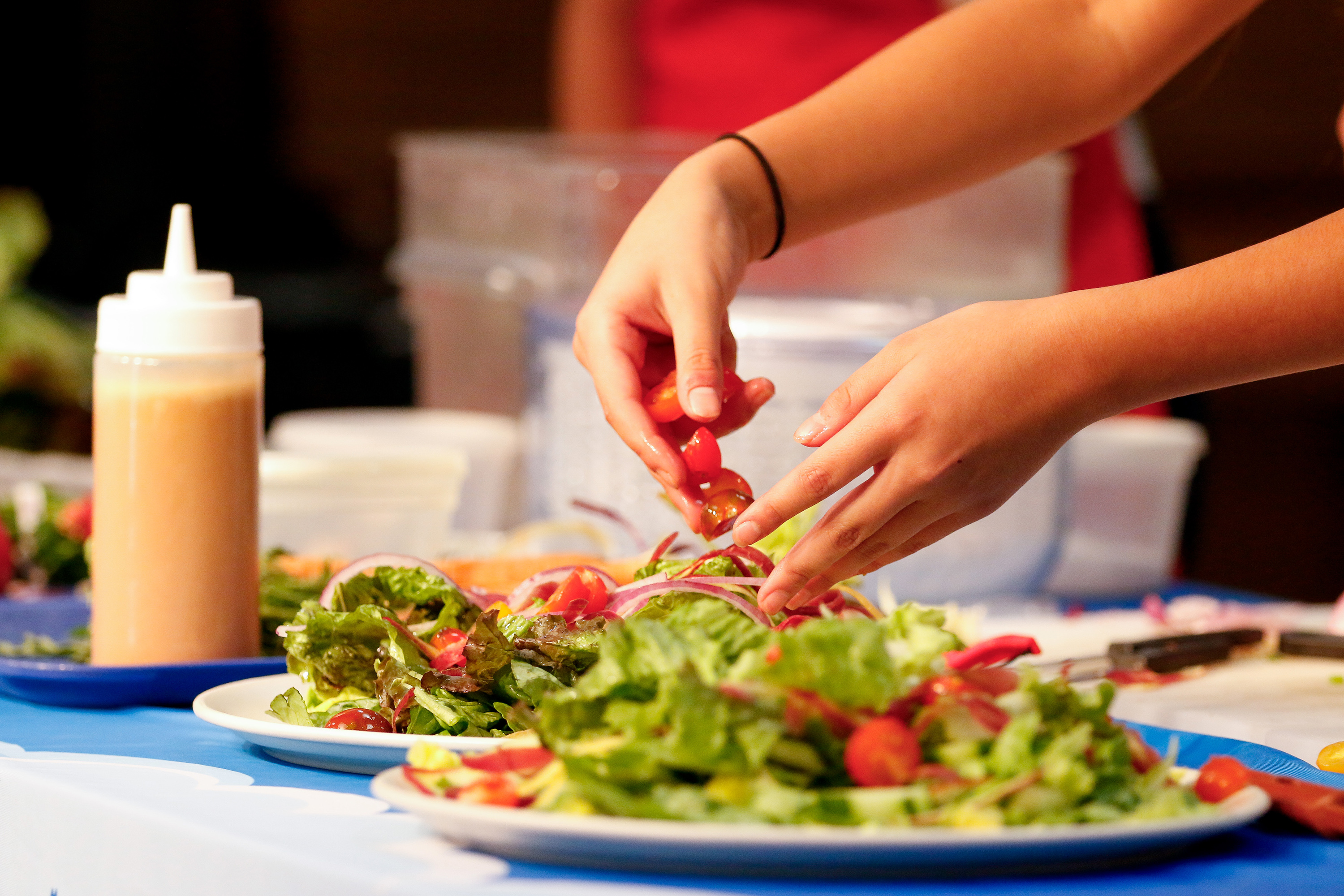 Closeup of a student plating a salad