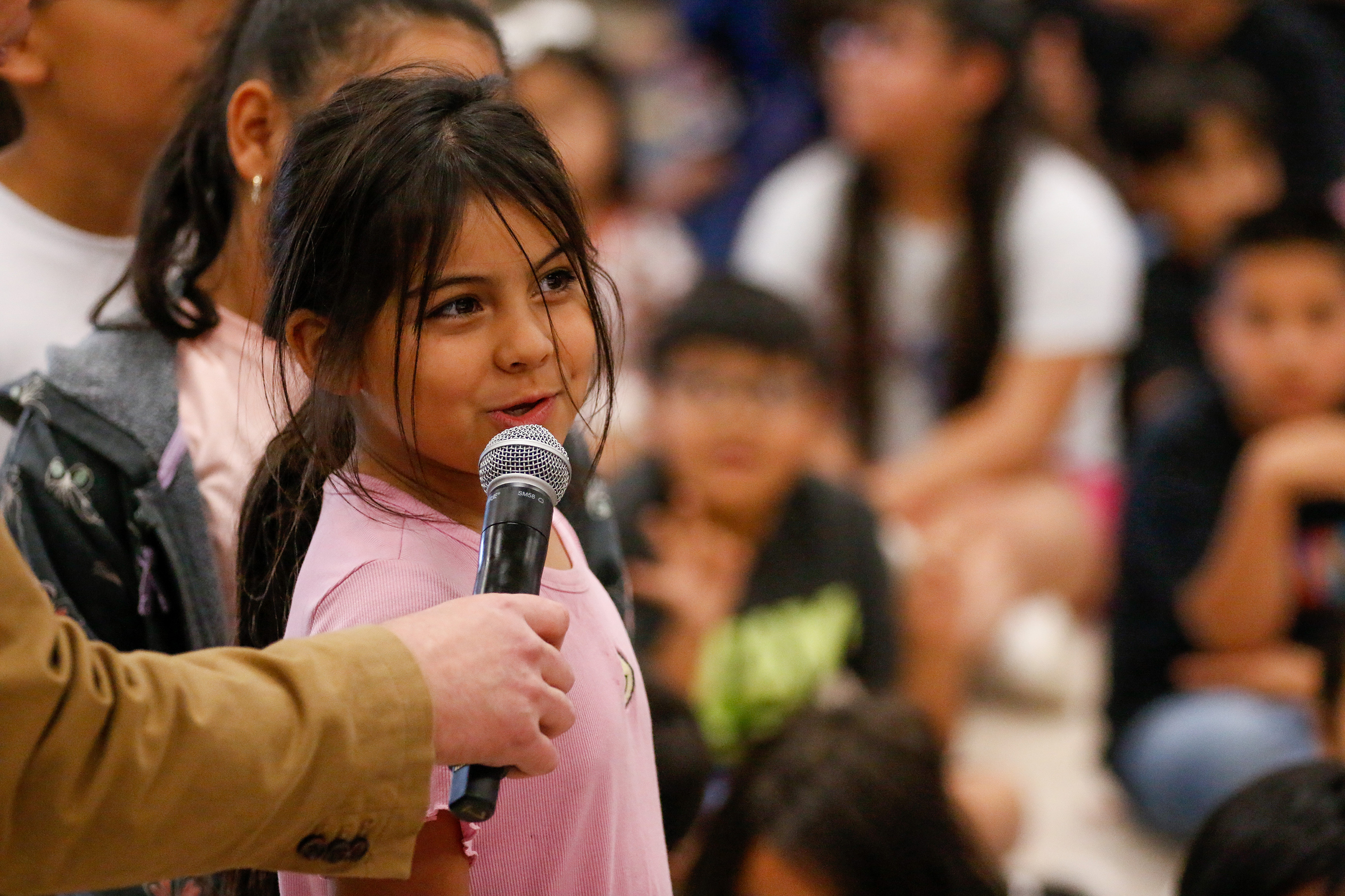 A girl in the audience speaks into a microphone