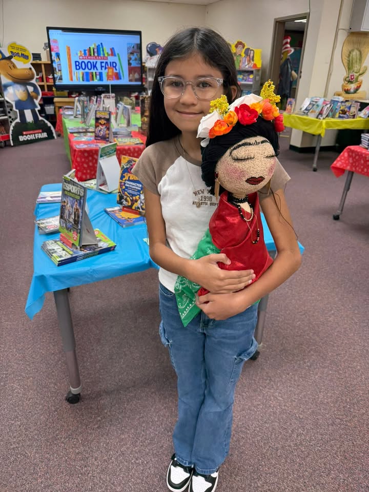 A girl shows off the Frida Kahlo doll she made