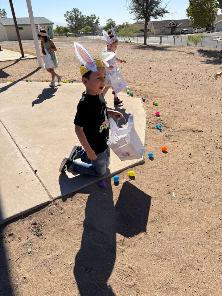 Kids in Easter bunny headbands hunt for colorful Easter eggs