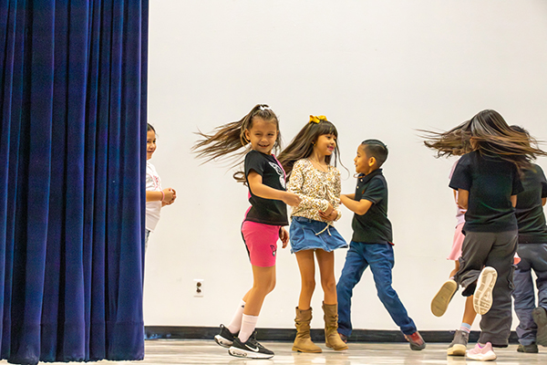 Students twirl on stage as they perform a dance