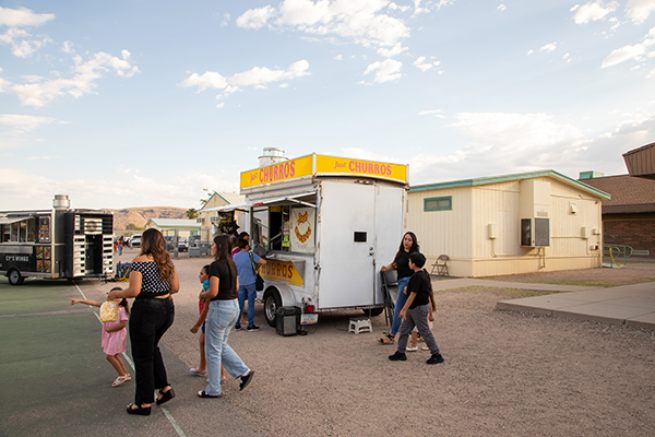 Families walk by the churro food truck outside