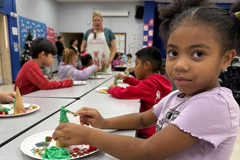A little girl decorates her ice cream cone Christmas tree