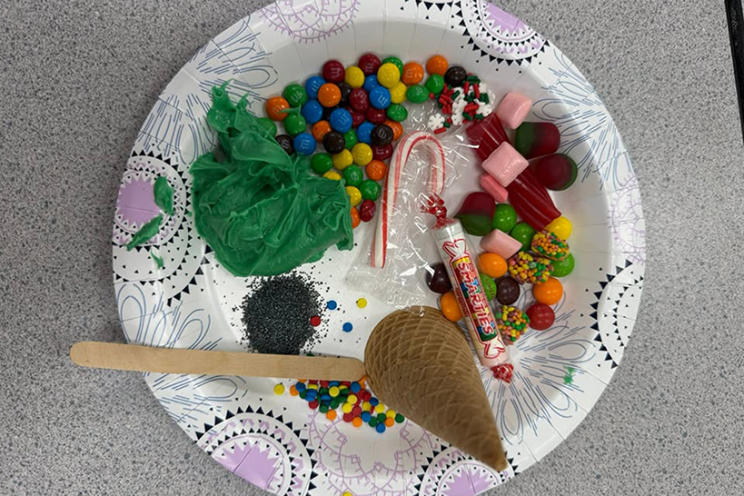 A paper plate filled with candy and other decorations for the ice cream cone Christmas tree