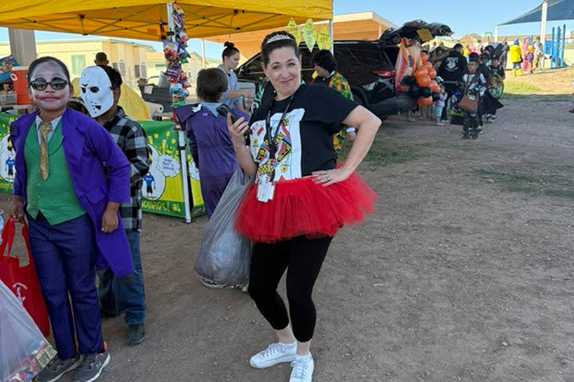 Students and a teacher pose in their Halloween costumes